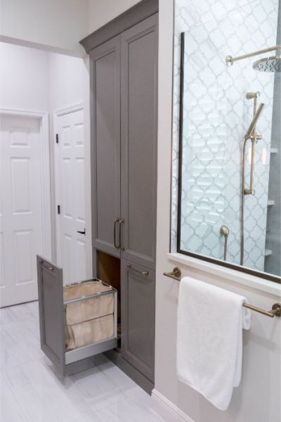 a white bathroom with gray cabinets and drawers