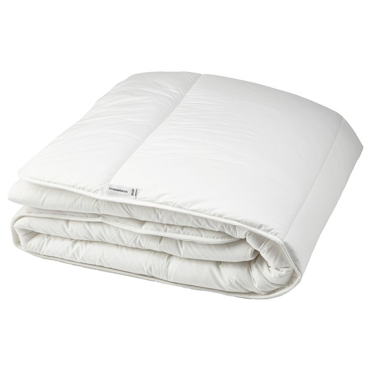 the white comforter is folded on top of each other