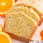 slices of orange bread on a cutting board next to sliced oranges