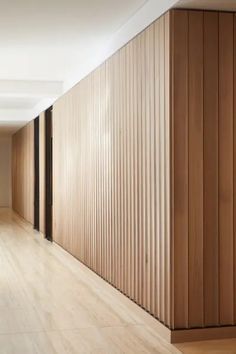 an empty room with wooden slats on the wall and flooring in front of it