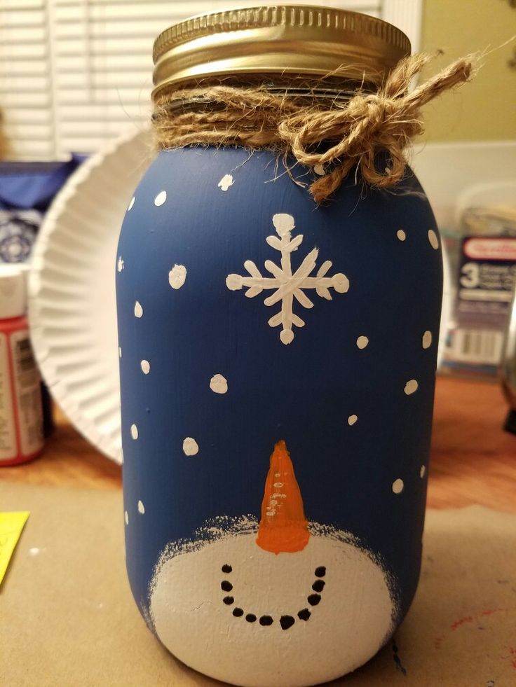 a painted mason jar with a snowman on it