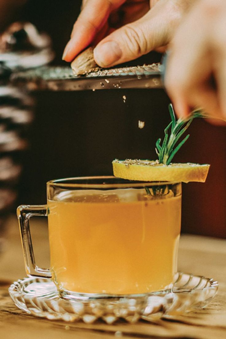 someone is adding rosemary to a cup of tea