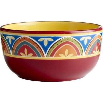 a red bowl with blue, yellow and green designs on the rim is sitting in front of a white background