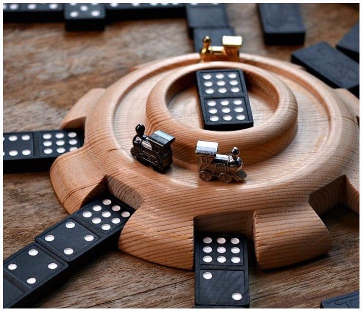 a wooden board game with black and white dominos on it's sides, surrounded by other pieces