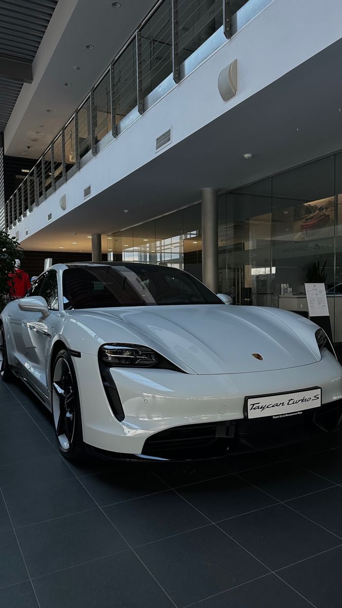 a white sports car parked in front of a building