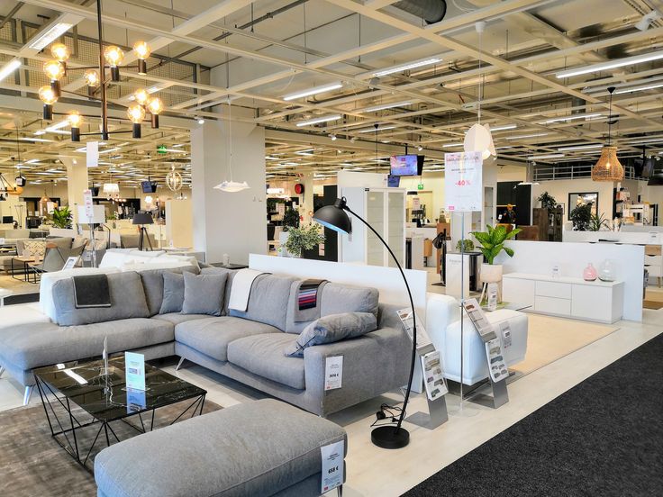 a living room filled with furniture and lots of lights hanging from the ceiling above it