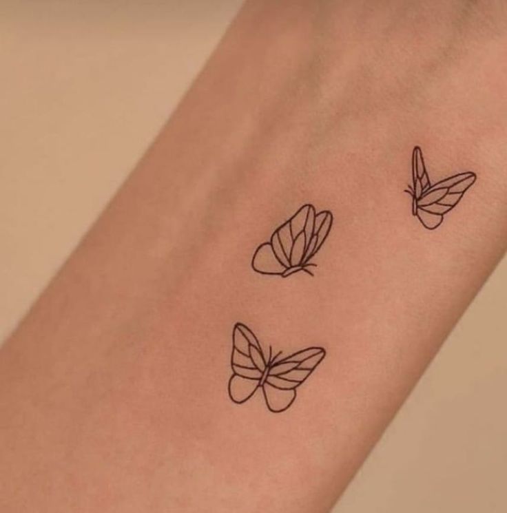 three butterflies tattoo on the arm