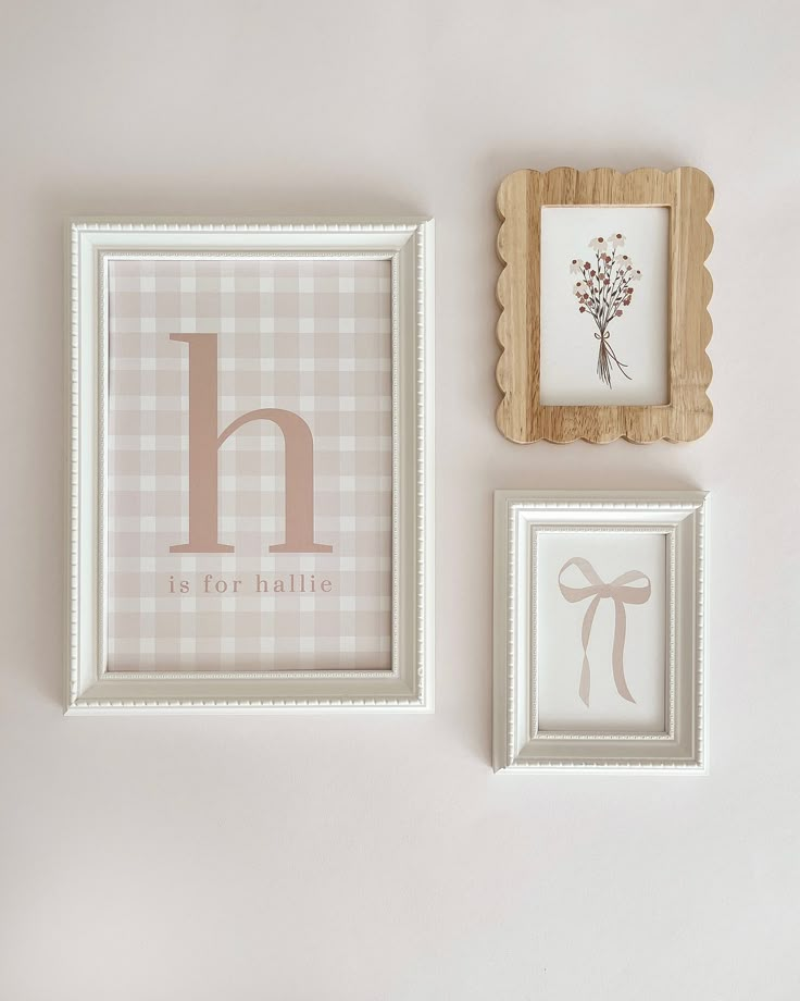 three framed pictures hang on the wall next to each other, one with a monogrammed letter