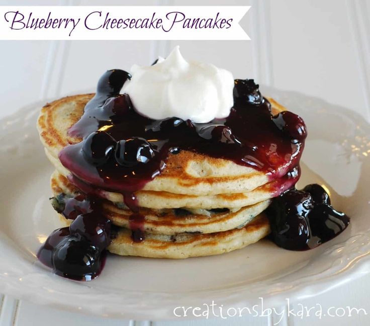 a stack of pancakes topped with blueberry cheesecake pancake sauce and whipped cream