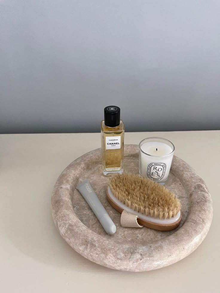 a white counter top with a brush, candle and some other items on it's tray