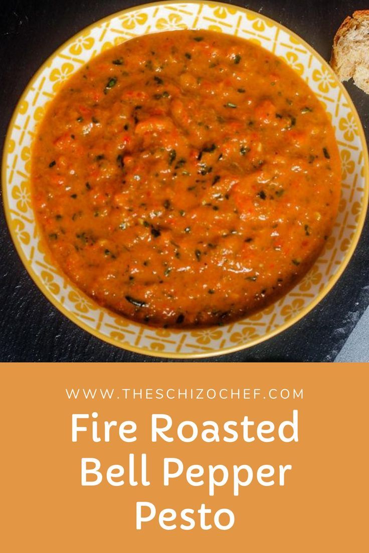 a bowl of fire roasted bell pepper pesto next to a slice of bread on a plate