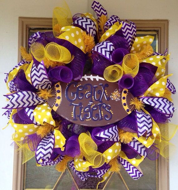 a purple and yellow football wreath with the words great team on it, hanging from a door