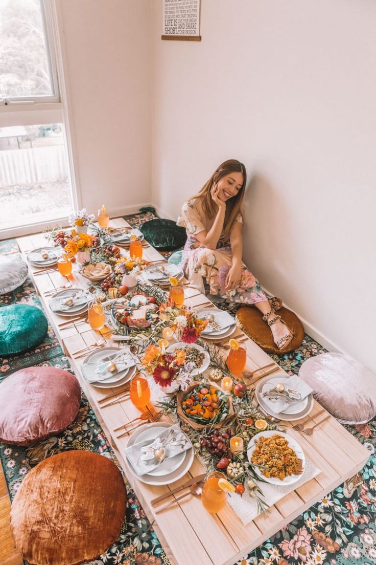 a woman sitting at a table with plates and bowls of food in front of her