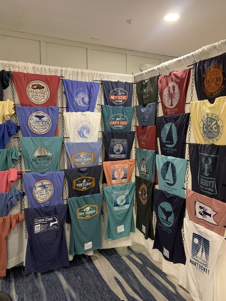 there are many t - shirts hanging up on the wall in front of each other