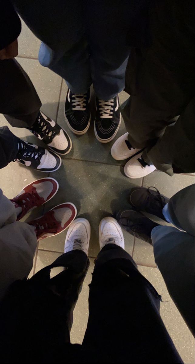 several people standing in a circle with their shoes on