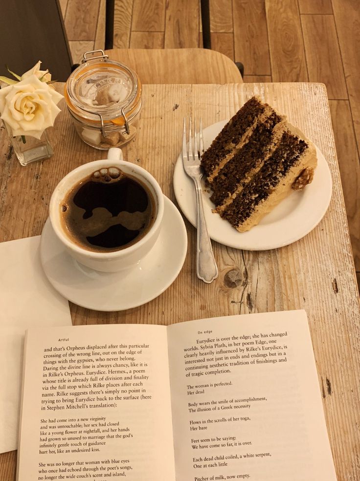 a piece of cake sitting on top of a table next to a cup of coffee