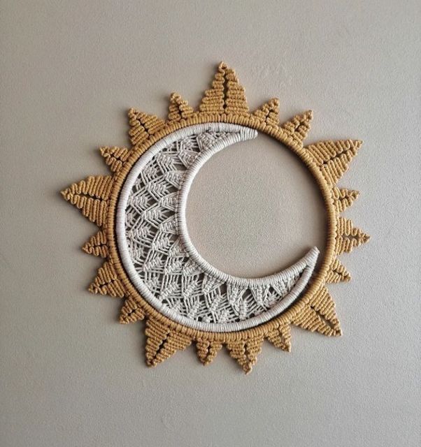 a crocheted doily sun and moon hanging on a wall in the shape of a circle