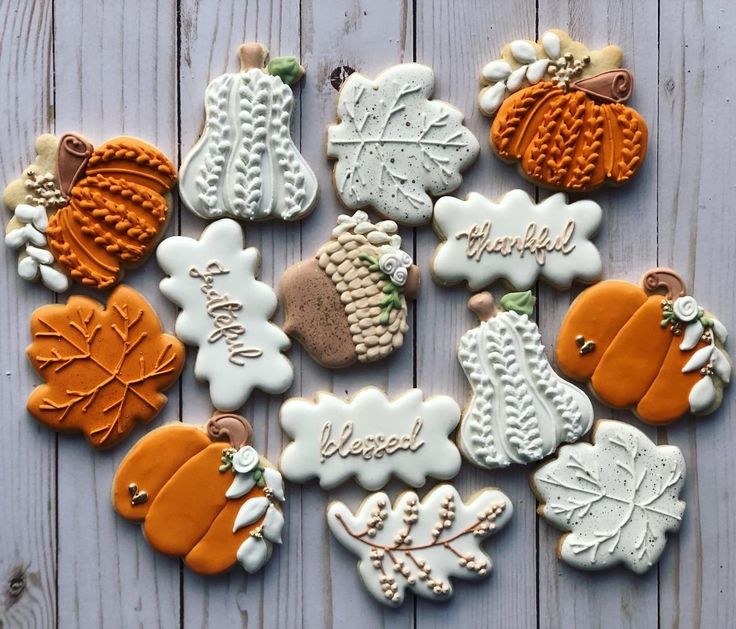 decorated cookies are arranged on a table with the words happy fall written in white and orange