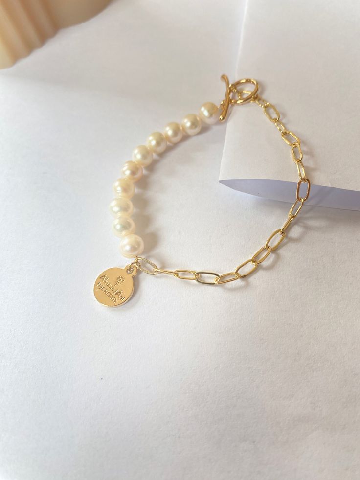 This bracelet is made of freshwater pearl and Paperclip chain. The delicate design and soft colour make it a symbol of tenderness, while the sturdy materials and edgy details add a touch of toughness. Whether you are going for a casual look or dressing up for a special occasion, this bracelet is versatile accessory that will add a unique touch to your style. Freshwater Pearl size is 5mm Paperclip is 14k gold filled Gold Pearl Bracelet In Trendy Style, Everyday Pearl Bracelets With Adjustable Chain, Chic Pearl Bracelet As Gift, Everyday White Chain Bracelet With Pearl Charm, Minimalist Beaded Bracelets With Pearl Chain, Chic Pearl Charm Bracelets As Gifts, Chic Pearl Charm Bracelet As Gift, Elegant Everyday Beaded Bracelets With Chain, Trendy Pearl Chain Bracelet For Gift