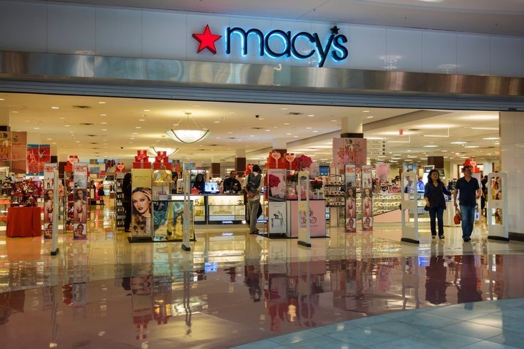 people are walking in front of macy's store with christmas decorations on the windows