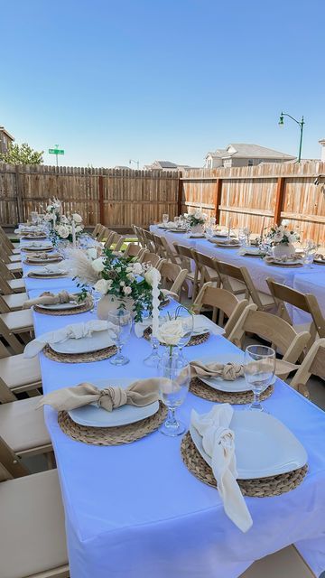 a long table set up with white and gold plates, place settings and napkins