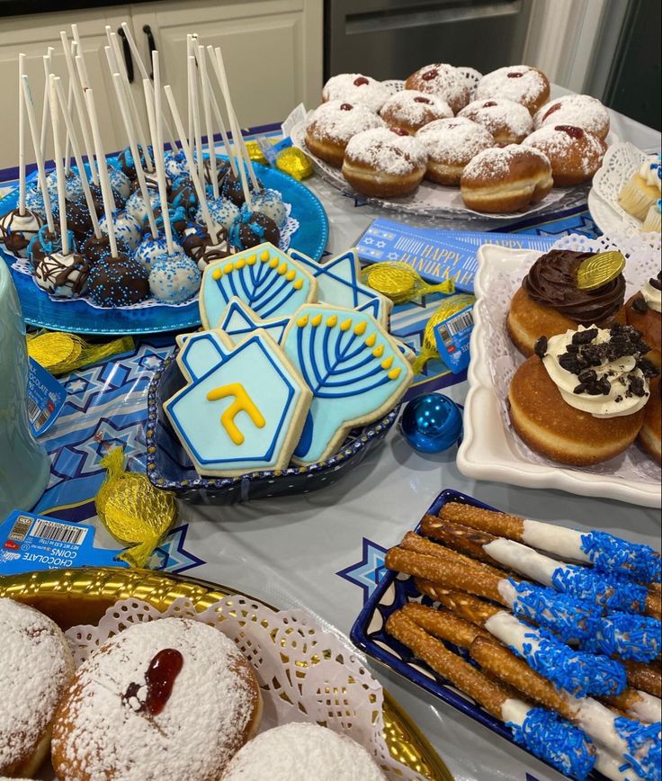 a table topped with lots of desserts and pastries on top of blue plates