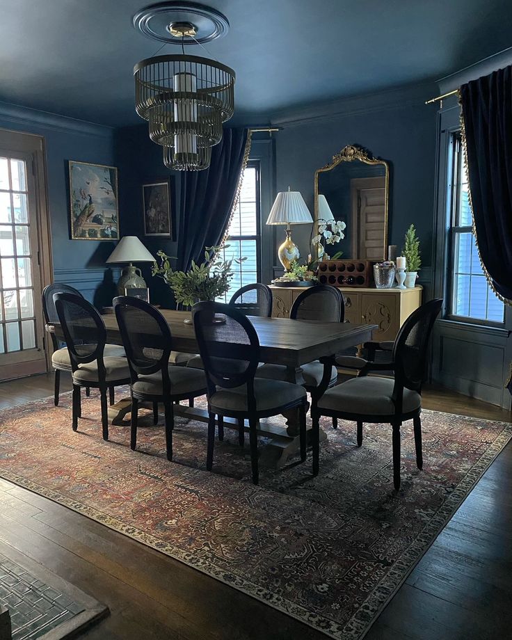 a dining room with blue walls and wooden flooring, chandelier hanging from the ceiling