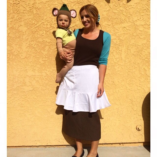 a woman holding a baby in front of a yellow wall