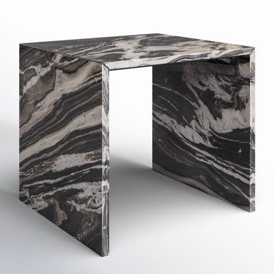 a black and white marbled table with an irregular design on the top, in front of a white background