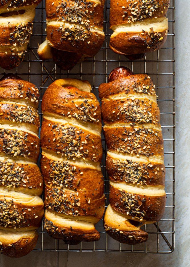 breads with sesame seeds and cheese on a cooling rack, ready to be baked