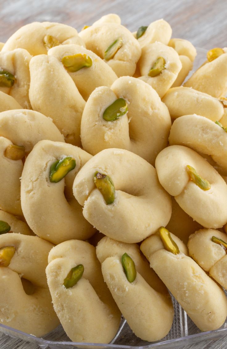 a bowl filled with cookies and pistachios on top of a wooden table