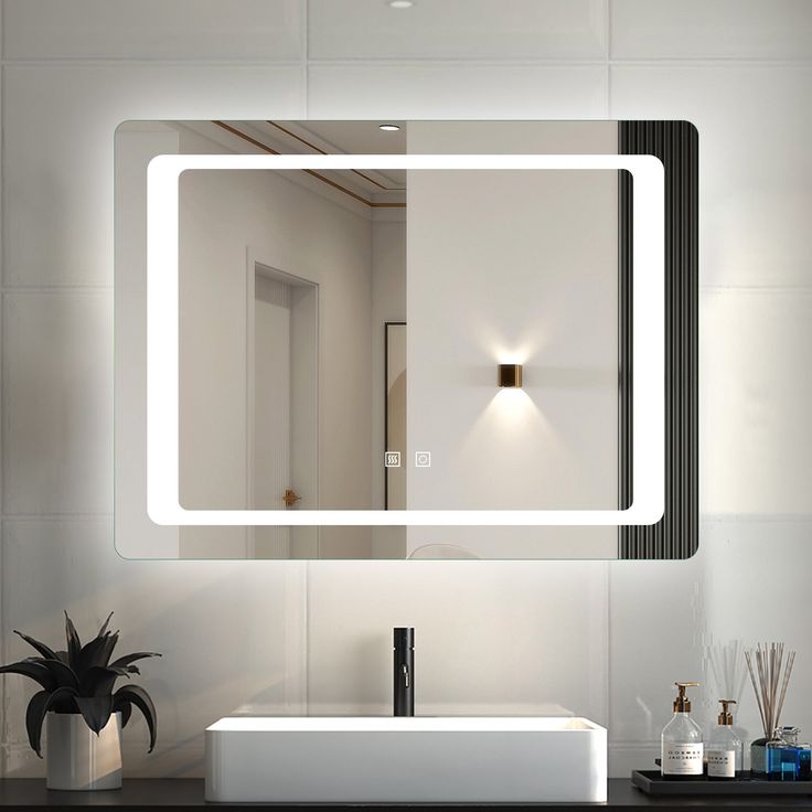 a bathroom sink with a mirror above it and a light on the wall behind it