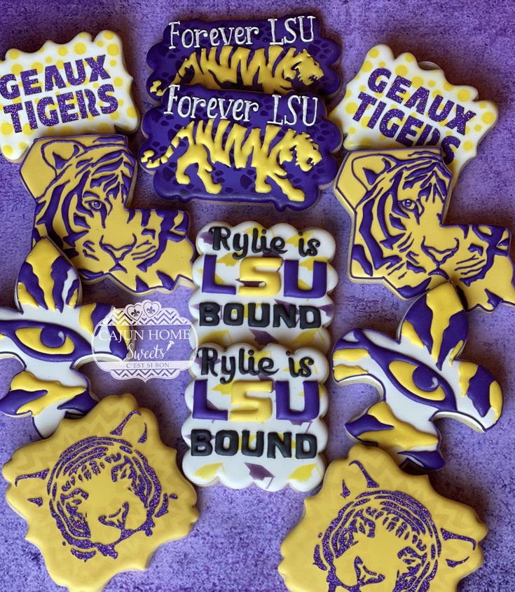 decorated cookies with purple and yellow tiger designs on them are arranged in the shape of letters