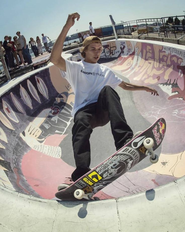 a man riding a skateboard up the side of a ramp at a skate park