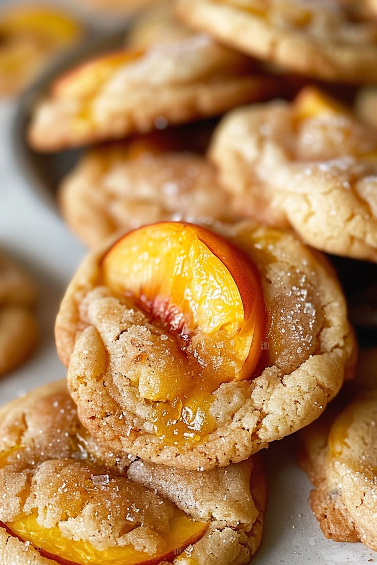 a pile of cookies with peaches and powdered sugar