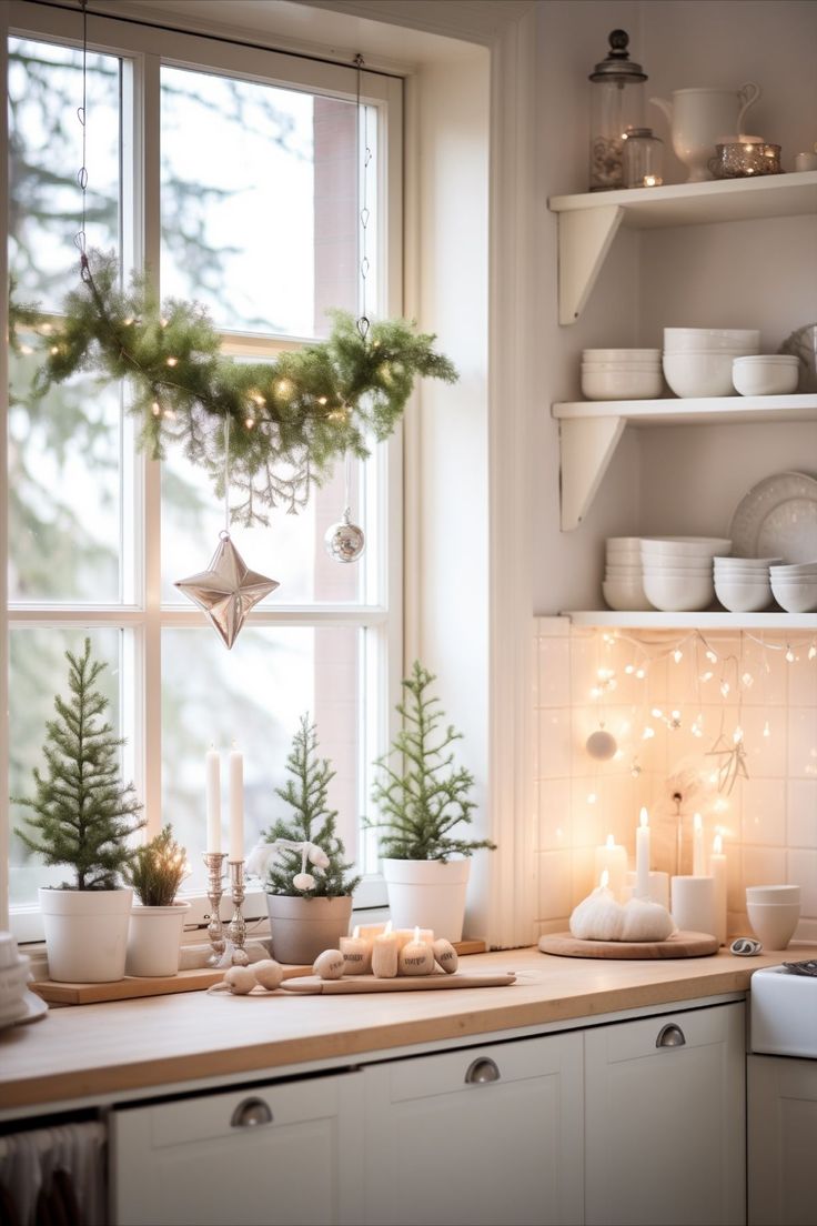 a kitchen counter topped with white dishes and christmas trees in front of a large window