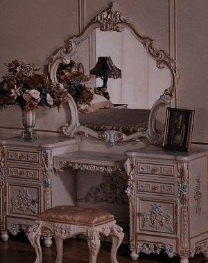 an ornate white vanity with mirror and stool