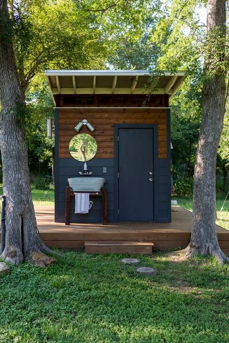 a small bathroom in the middle of some trees