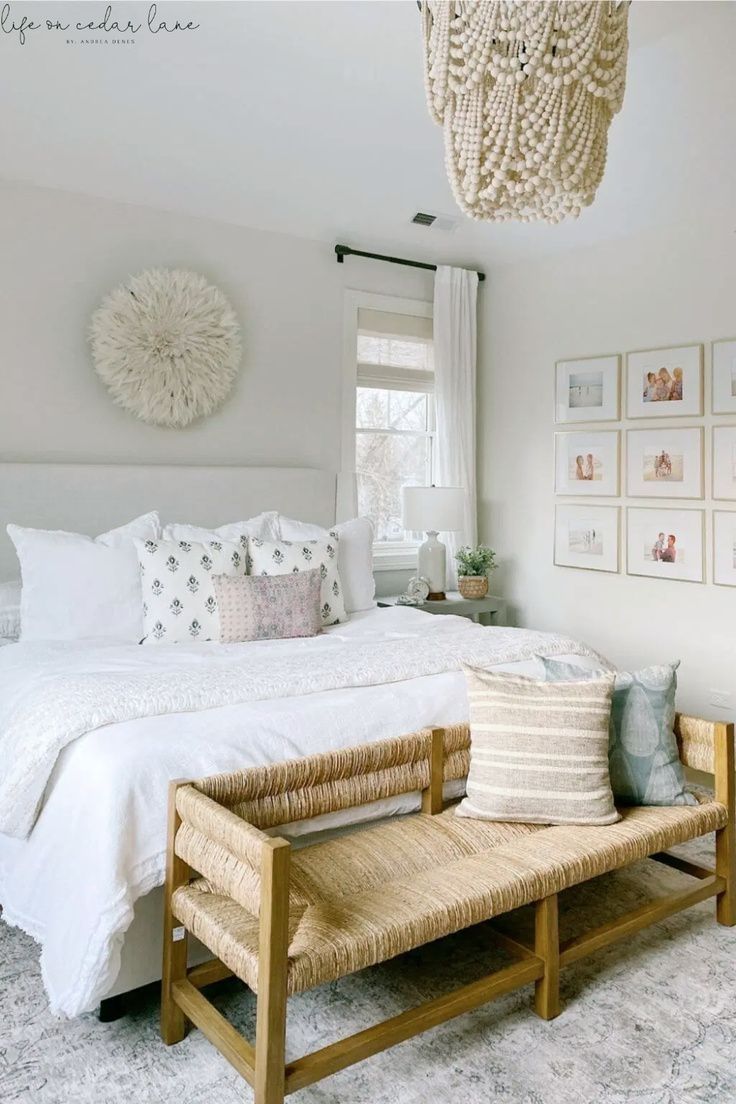 a bedroom with a bed, bench and pictures on the wall