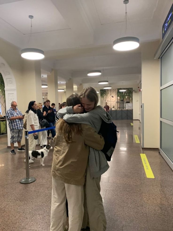 two people hugging each other in an airport