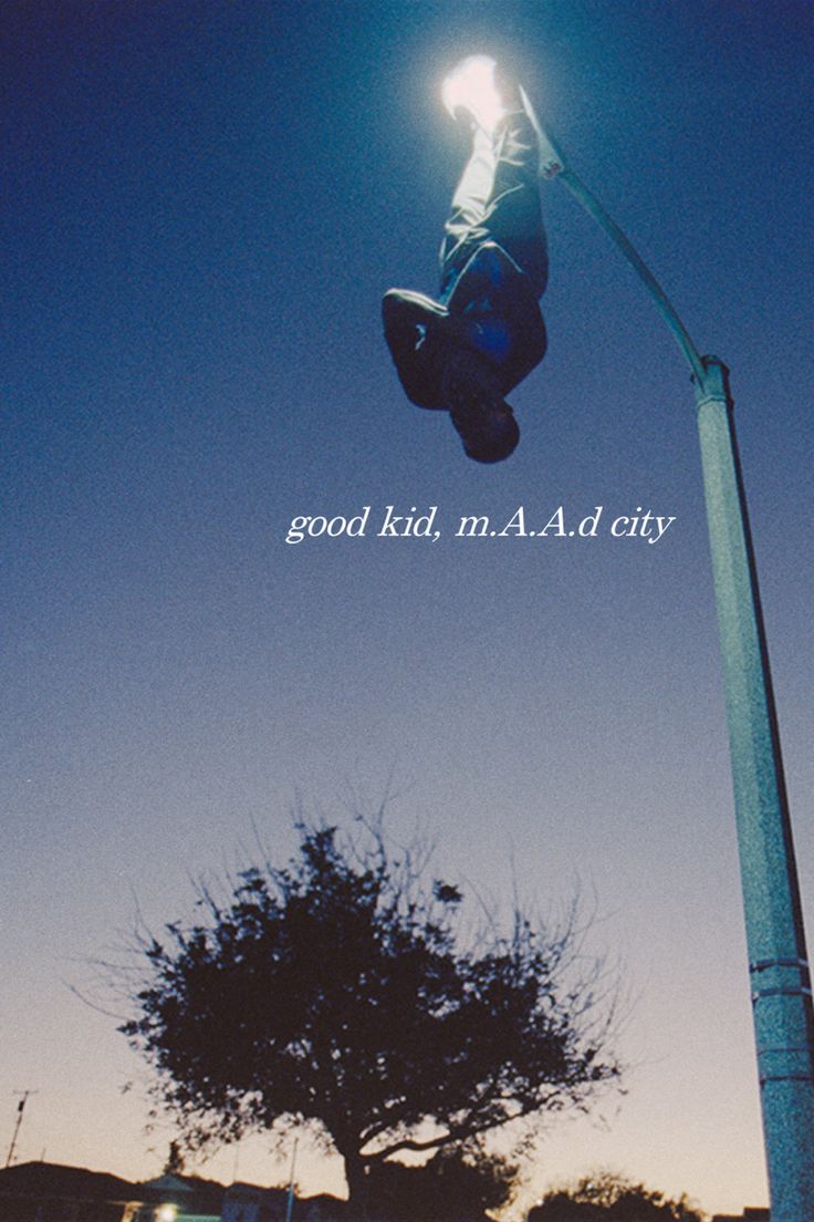 a person jumping up in the air on a skateboard under a street light at night