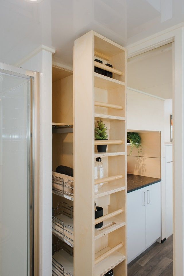 an open pantry with lots of drawers and shelves in the corner, next to a walk - in shower