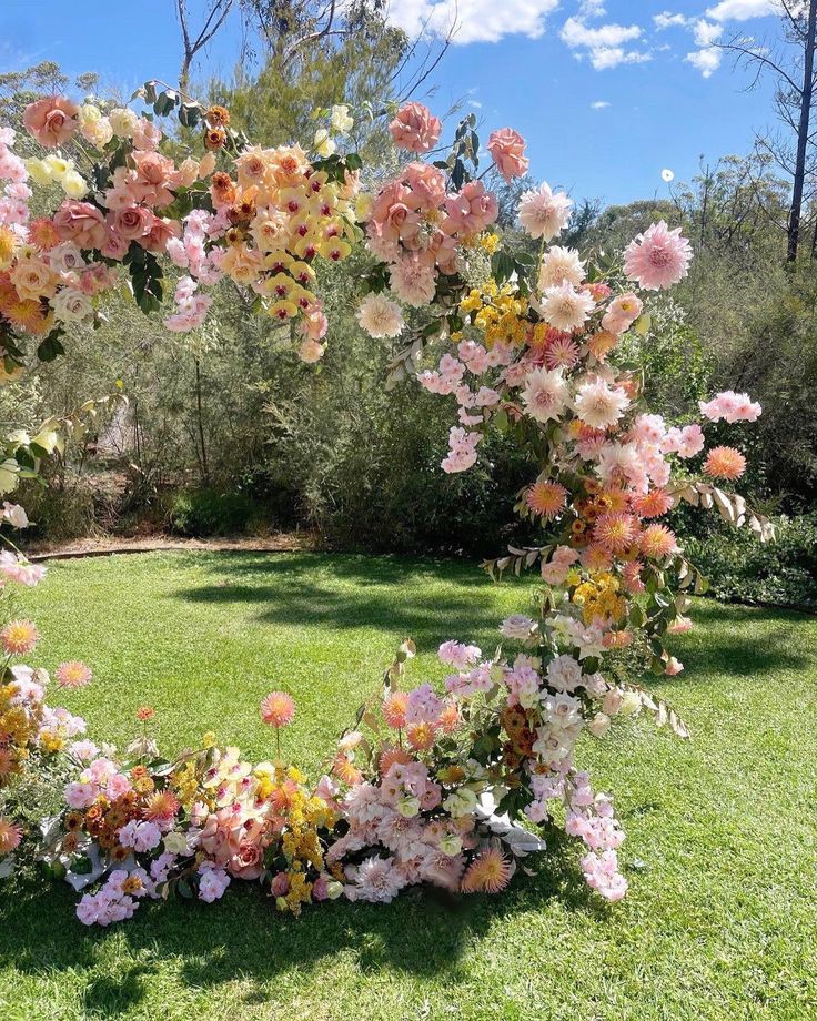 an arch made out of flowers in the grass