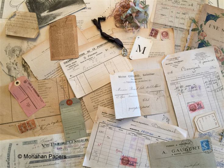 many old papers and tags are scattered on top of each other, including one with the letter m