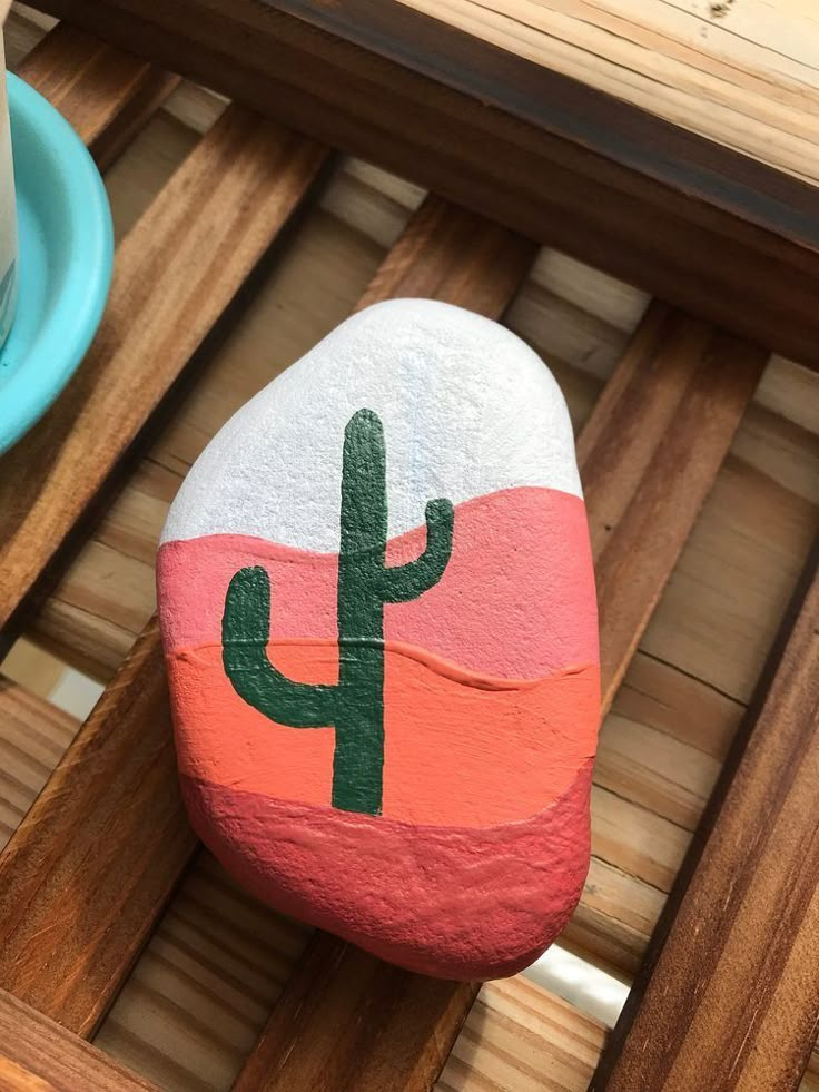 a painted rock with a cactus on it