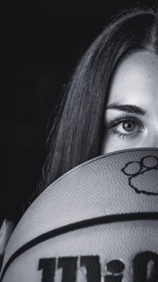 a woman holding a basketball in front of her face