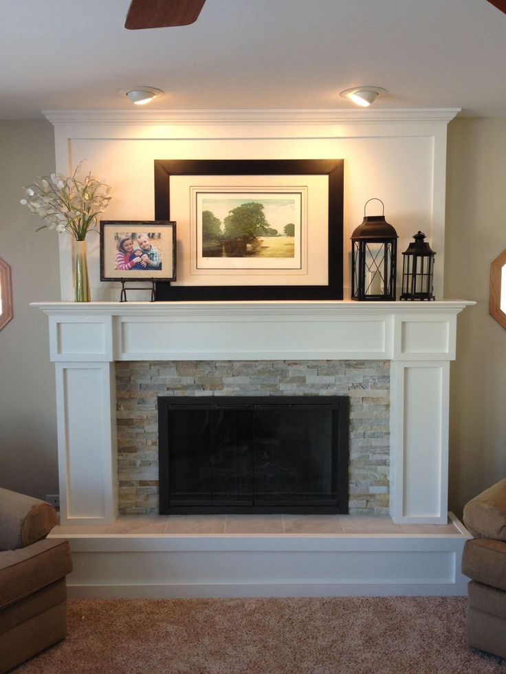 a living room with a fireplace and pictures on the mantle