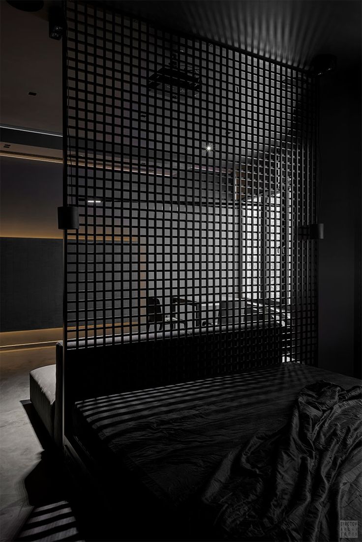 a black and white photo of a bed in a dark room