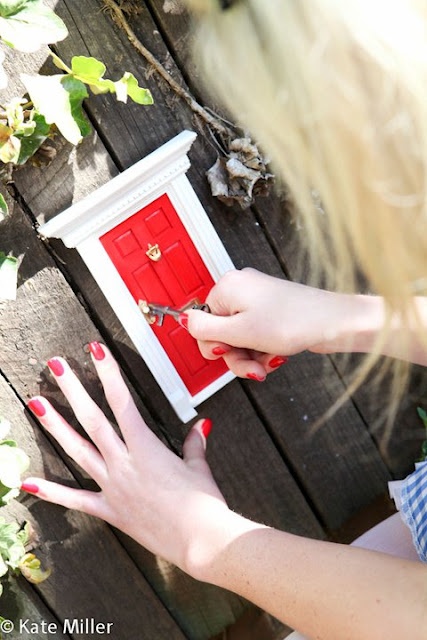 a woman holding a red door with nails on her fingers and nail polishing it