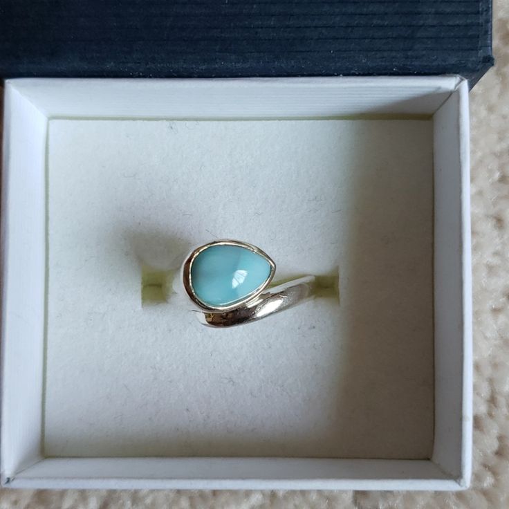 Larimar Is A Rare Blue Variety Of The Silicate Mineral Pectolite Found Only In The Dominican Republic, In The Caribbean. Its Coloration Varies From White, Light-Blue, Green-Blue To Deep Blue. This Gorgeous Ring Is Simple And Elegant. Elegant Blue Larimar Rings, Elegant Blue Larimar Turquoise Ring, Blue Larimar Opal Ring, Blue Larimar Teardrop Jewelry, Blue Teardrop Larimar Jewelry, Elegant Turquoise Larimar Ring As Gift, Blue Larimar Jewelry For Anniversary, Elegant Turquoise Moonstone Ring In Sterling Silver, Blue Larimar Cabochon Rings